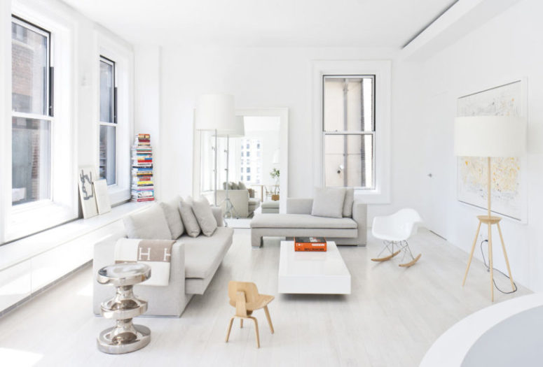 The living room features some comfortable grey furniture, a stack of colorful books and a world map plus lots of light The living room features some comfortable grey furniture, a stack of colorful books and a world map plus lots of light