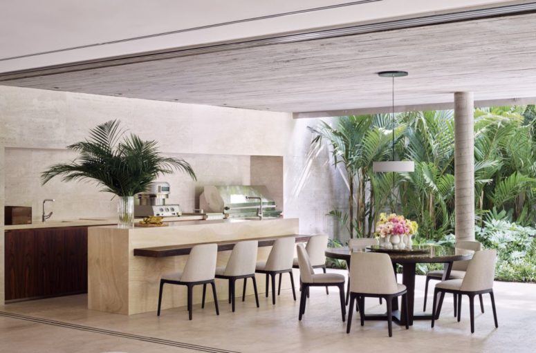 The kitchen features only lower cabinets, a stone kitchen island and a chic dining space opened to outdoors