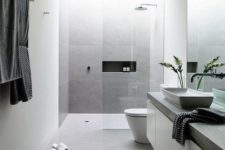 08 a clean minimalist bathroom done with white concrete and grey tile walls plus stone countertops