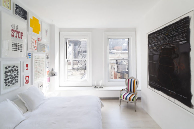 The bedroom is done with a bright gallery wall, a large chalkboard and a cozy bed