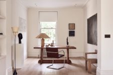 09 The home office features a chic wooden desk and a leather chair plus some art