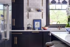 09 a navy kitchen with gold touches, a white subway tile backsplash and patterns feels retro and very chic