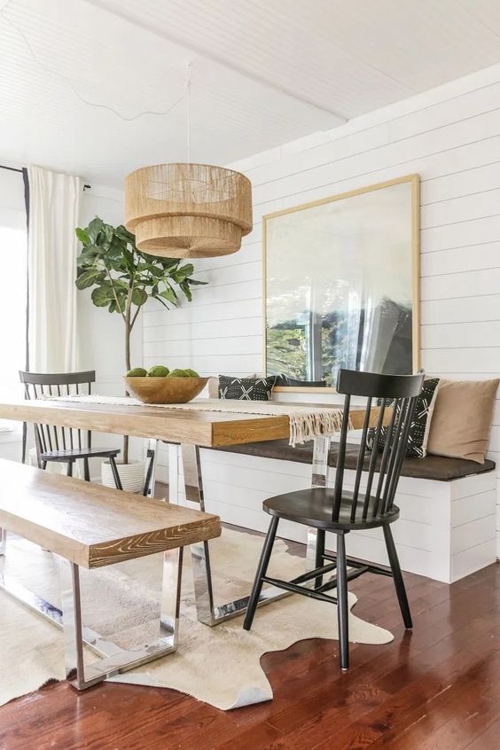 a cozy dining space with a table on a metal base and matching benches that repeat the table design