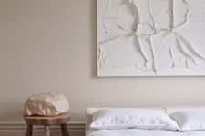 11 Another bedroom shows off a textural artwork and a comfy bed