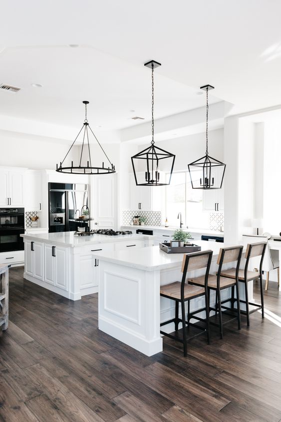a large neutral kitchen with two kitchen islands - one for cooking and another for eating