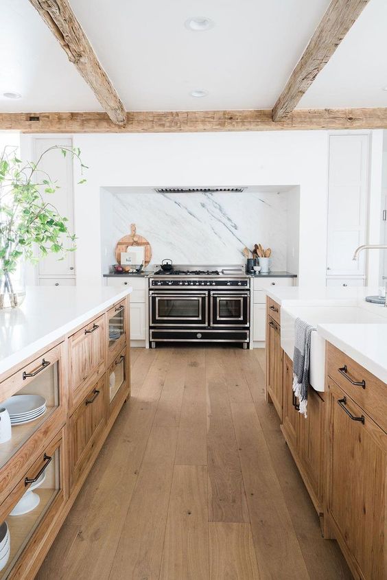 two large wooden kitchen islands with open and closed storage and white countertops look very stylish