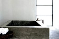 15 an ultra-minimalist bathroom done in concrete with a large soaking bathtub and white concrete walls
