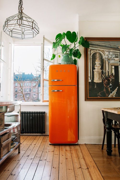 try a bright orange fridge to bring a fun and colorful touch to your kitchen and renovate it at once
