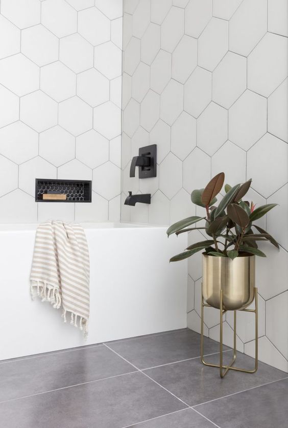 a neutral bathroom done with large scale hexagon tiles covering the walls for an ultra modern feel
