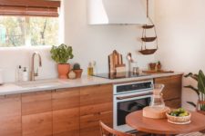 21 a warming and welcoming kitchen with wooden furniture, wooden shutters and natural greenery in pots