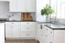 25 a classic white kitchen with black countertops that create interest due to the contrast they bring