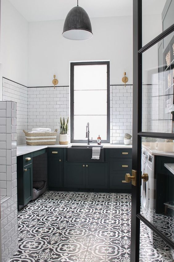 a gorgeous black and white farmhouse kitchen with a printed tiled floor that adds interest to the space