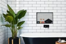 27 a chic bathroom with a black retro free-standing bathtub that matches the space perfectly