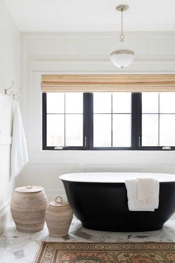 a chic and welcoming bathroom with a black free-standing bathtub that makes a statement here