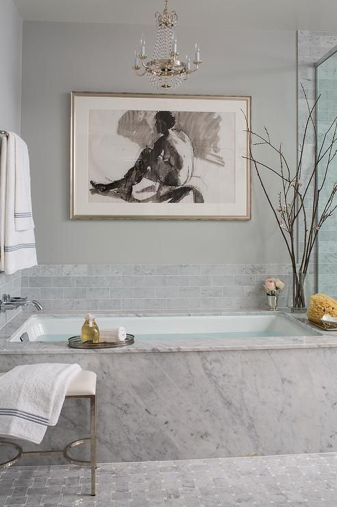 grey marble covers the bathtub and grey marble tiles for a backsplash create a chic unified look