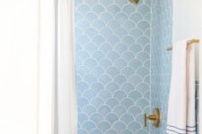 39 light blue scallop tiles and brass fixtures create a cool and chic combo for a bathroom