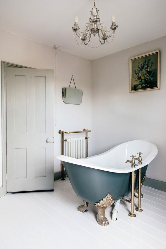 a vintage bathroom in neutrals spruced up with brass fixtures here and there and an elegant chandelier