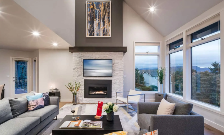 a clean modern living room in light shades and a built-in fireplace clad with white faux stone to match