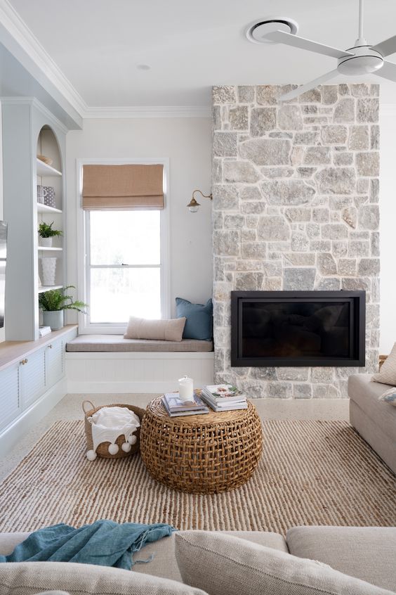a contemporary living room with a built-in fireplace, grey seating furniture, a jute rug, niche shelves and greenery