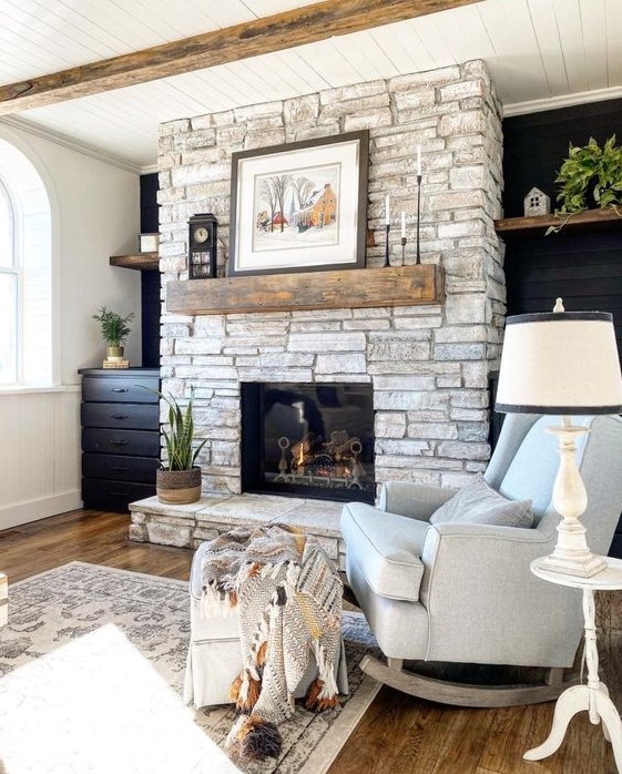 a farmhouse living room with a whitewashed stone fireplace and neutral and elegant furniture