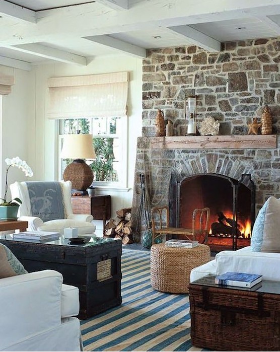 a neutral and chic living room with a stone fireplace that becomes a centerpiece, adds interest and texture to the space