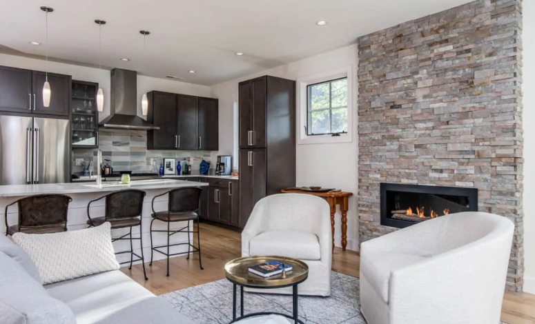 a stylish eclectic living room with a built-in fireplace clad with faux stone, which is a cool warming up idea