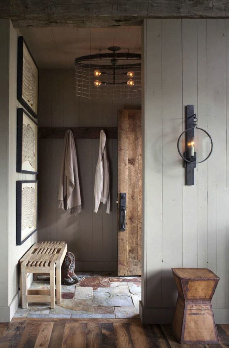 The entryway is done with white beadboards, a stone floor, some simple wooden furniture