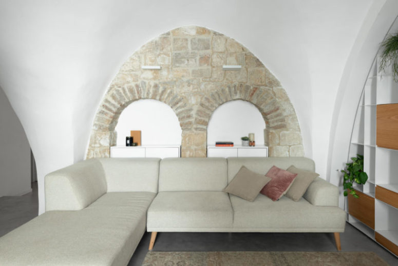 The living room is done with comfy shelving, an L-shaped sofa and some hidden storage units