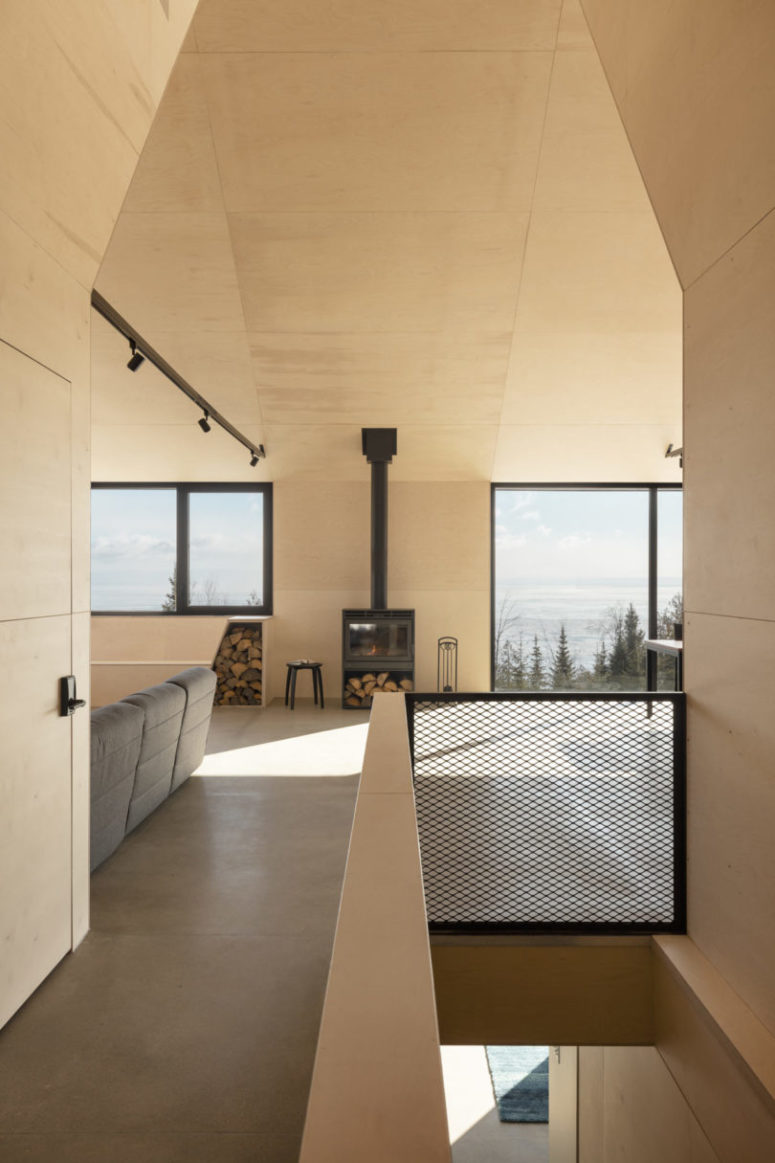 Inside there are vast spaces all clad with light colored plywood, with lots of windows and touches of black for drama Inside there are vast spaces all clad with light-colored plywood, with lots of windows and touches of black for drama