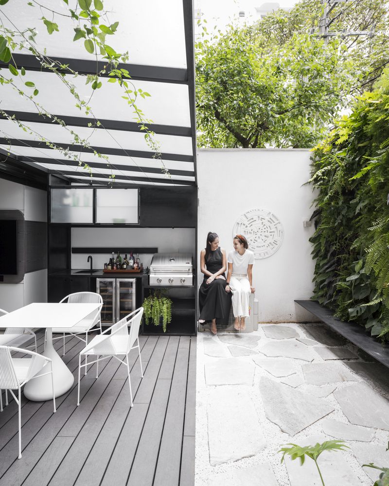 The kitchen opens up to a private courtyard with a green wall that enlivens the whole space at once
