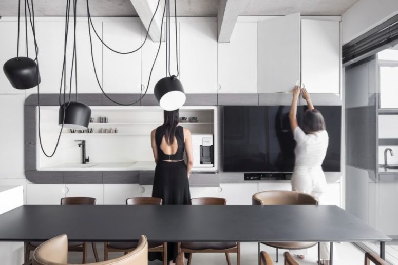 The kitchen itself is done with sleek white cabinets, with matte lamps and faucets plus a black table The kitchen itself is done with sleek white cabinets, with matte lamps and faucets plus a black table