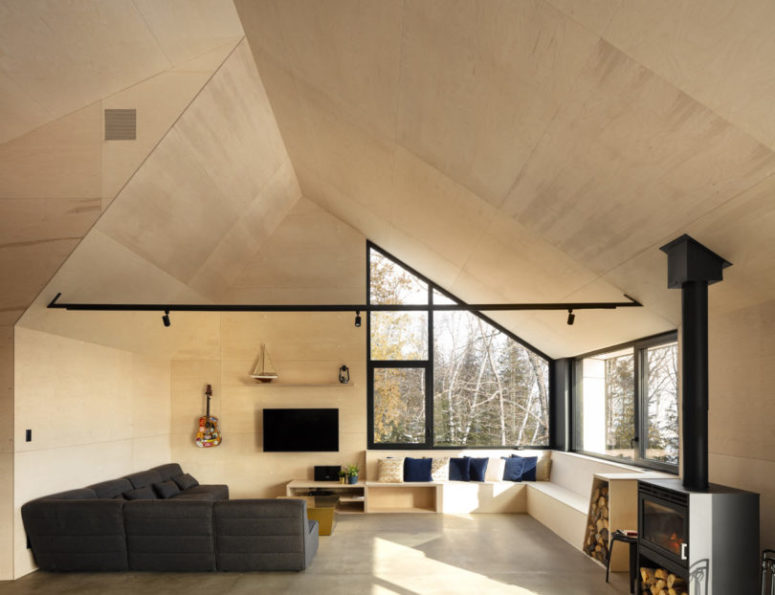 The living room is done with a graphite grey sofa, a built-in bench with storage and a hearth for warmth and coziness