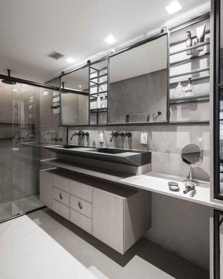 The bathroom is sleek and elegant, with plywood, concrete and stone, with a glass enclosed shower space The bathroom is sleek and elegant, with plywood, concrete and stone, with a glass enclosed shower space