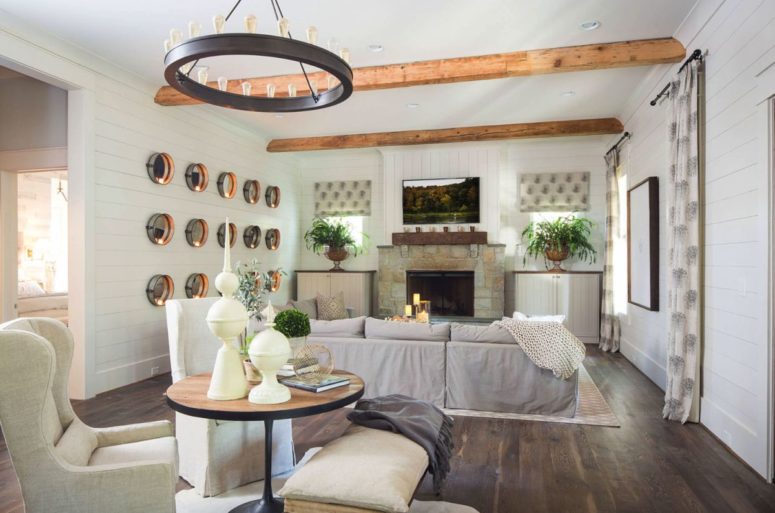 The living room itself shows off a gorgeous stone fireplace, printed curtains and an arrangement of mirrors