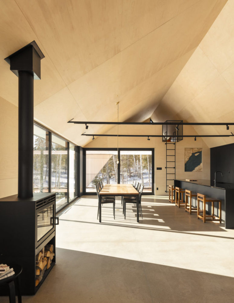 The open plan space includes a dining room and a kitchen, too, a black kitchen island and black chairs