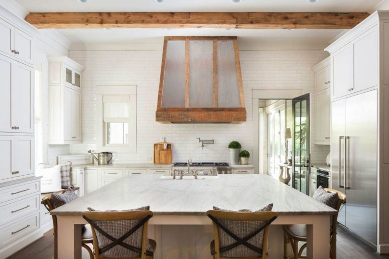 The kitchen is done with neutral cabinets, there's a large kitchen island and table in one