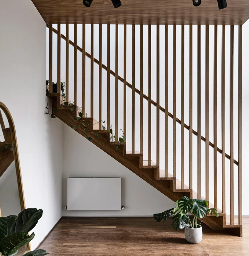 The staircase is divided with a wood plank screen from the rest of the space