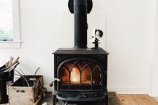 06 a large vintage black stove on a tile platform is a cool idea to add coziness to your home decor