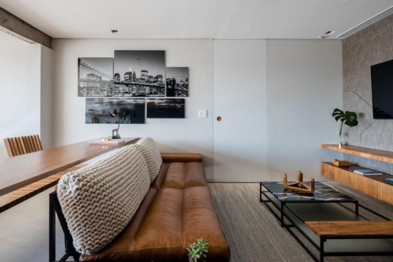 The living space is completed with a leather and crochet sofa and there's a long console table behind that may be used as a desk