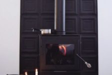 07 a black modern stove with a black panel wall behind it and a modern candelabra for a bold look