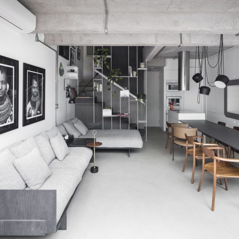 The staircase is separated from the rest of the space with an airy divider with greenery, books and other stuff The staircase is separated from the rest of the space with an airy divider with greenery, books and other stuff