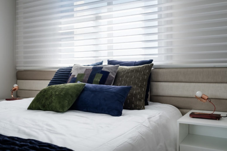The master bedroom is done with a comfy bed and some pillows and nightstands