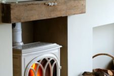 12 a vintage white wood-burning stove placed into a niche and with a mantel to remind of a classic stove