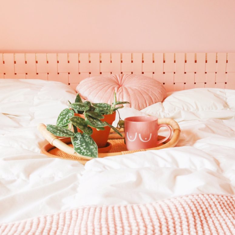 an IKEA Malm headboard hacked with blush fabric that is woven over the existing piece