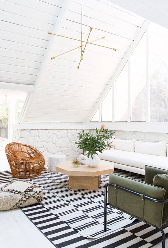 layered and different black and white rugs set the tone for this neutral Californian space, and a printed ottoman adds to it