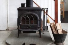 18 a modern farmhouse space with a vintage black wood burning stove and a cozy rug next to it