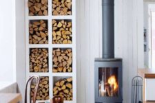 20 a Scandinavian space with a modern and cool wood burning stove plus an elegant open storage unit for firewood