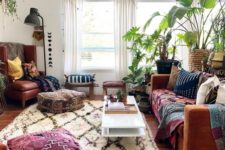 a bright boho space with printed rugs and throws, potted greenery and cool floor lamps and cushions
