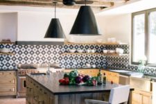 a bright modern Spanish kitchen with wooden beams, a printed tile backsplash, pendant lamps and a heavy wooden kitchen island