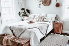 a neutral boho bedroom with layered crochet textiles, woven and wicker details, a dream catcher on the wall